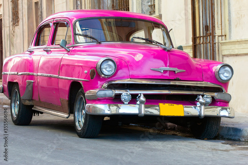 A classic car driving in a street in Havana. These old and classic cars are an iconic sight of the island