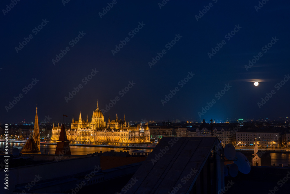 Hungarian Parliament with full moon in the night view from pest hill in Budapest