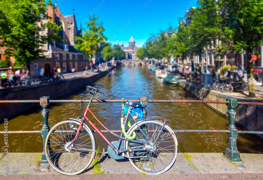 Bicycle on the bridge with Netherlands traditional houses and Amsterdam canal in Amsterdam 