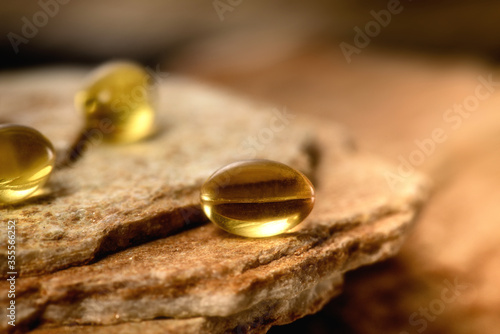 Vitamin capsules. Soft gel capsules on the surface of natural stone. Сlose up fish oil on gold background. Omega 3. Сoncept of health. Омега 3. gold pattern