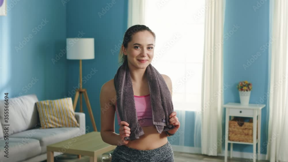 Portrait of slim pretty woman, standing at home after morning workout, smiling at camera, enjoying her perfect body shape, Caucasian, white, Slow motion.