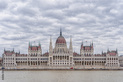 Hungarian Parliament facing Danube with clouds overhead in Budapest winter morning