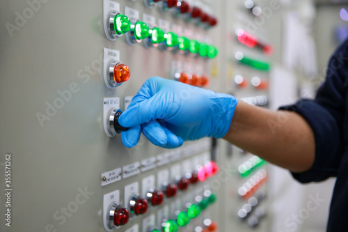 Photography Technician hand operate switch and button of control panel