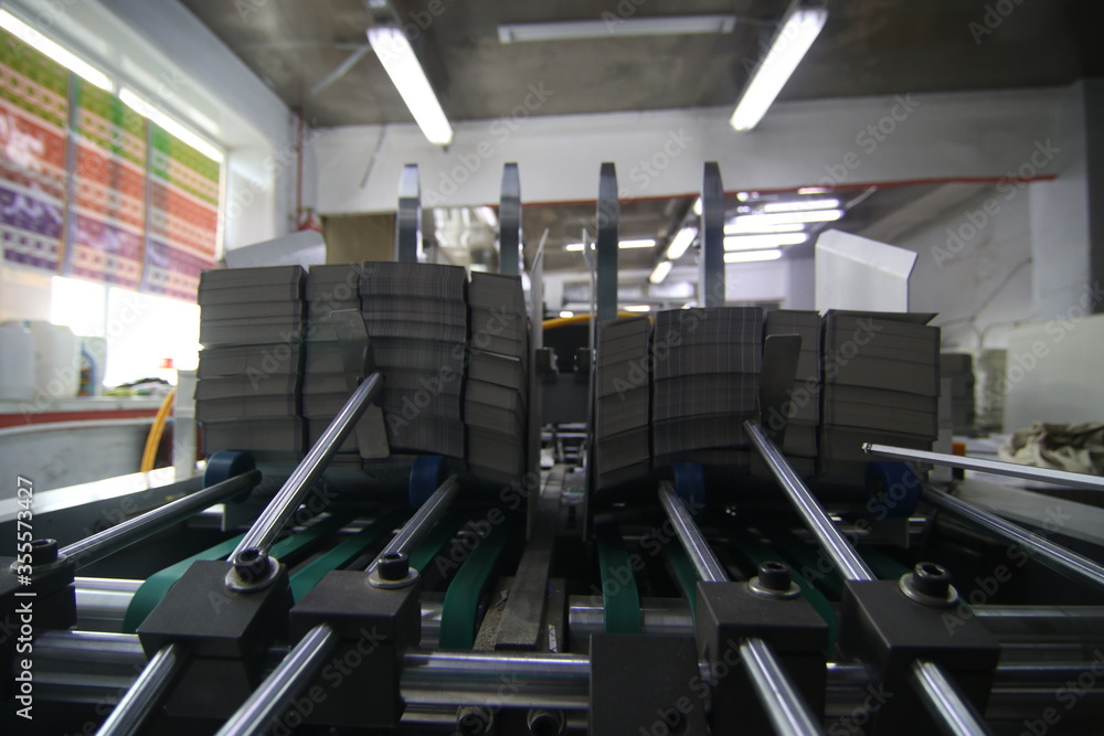 Fototapeta premium stacks of printed sheets of cardboard on wooden pallets closeup. printing industry