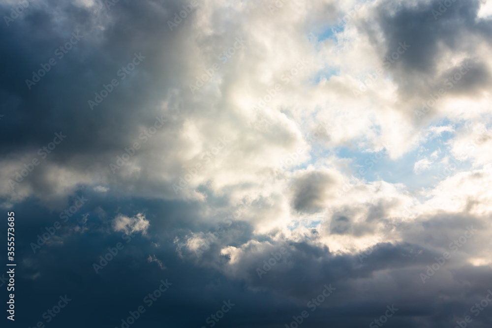 Blue sky background with white dramatic clouds and sunlight, vast sky background