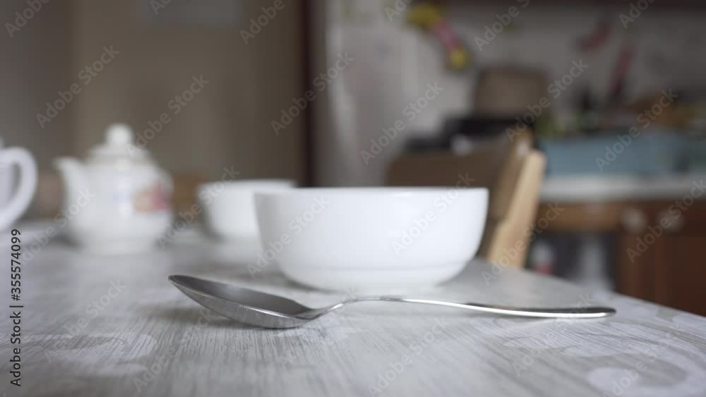 man puts on the table a plate and a spoon man puts on the table a plate and a spoon