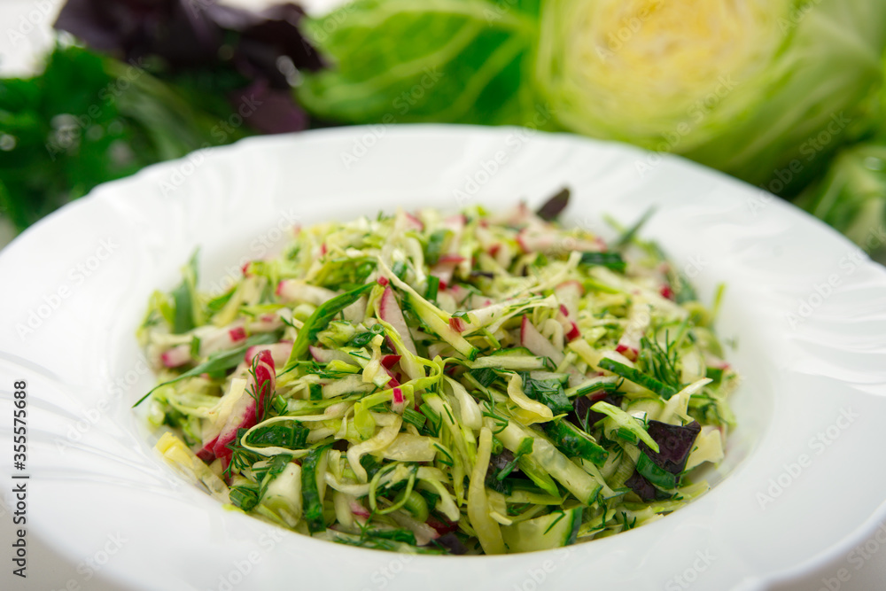 Fresh salad of white cabbage with tarragon on a white plate. Vegetarian and vegan food. A healthy and orangic dish. Fresh salad of white cabbage with tarragon on a white plate. Vegetarian and vegan food. A healthy and orangic dish.