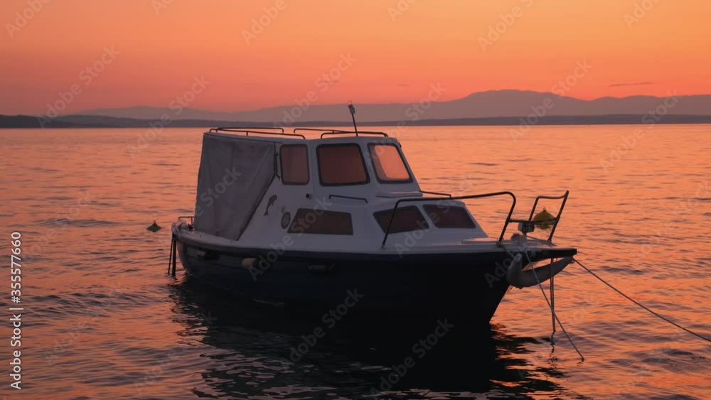Slow motion shot: Sunset by the sea. Fishing boat sways in the waves. 4k. Slow motion Slow motion shot: Sunset by the sea. Fishing boat sways in the waves. 4k. Slow motion