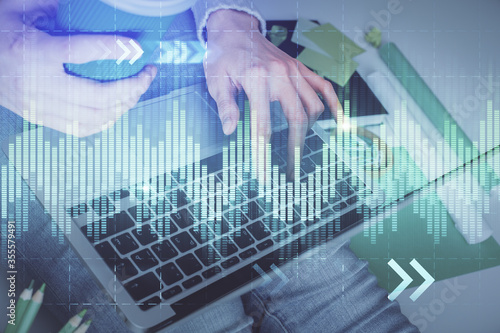 Double exposure of woman hands typing on computer and forex chart hologram drawing. Stock market invest concept. © peshkova