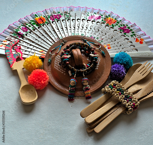 table top photograph of traditional mexican fan, wooden utensils and ornaments 