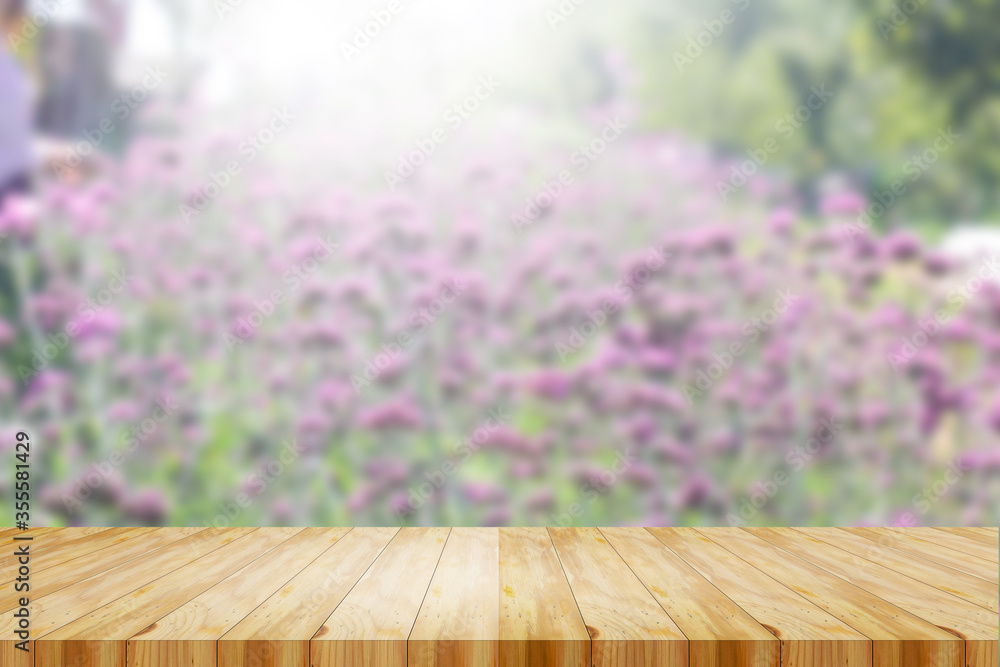 wood table top on blur background of blooming Verbena field on summer sunset - can be used for display or montage your products