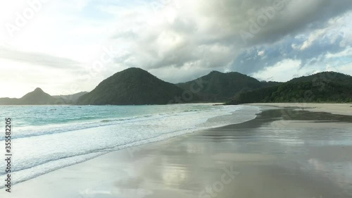 View from above, stunning aerial view of the Selong Belanak beach flanked by a green mountainous coast. Selong Belanak Beach is a white sand beach located in Lombok, West Nusa Tenggara, Indonesia photo