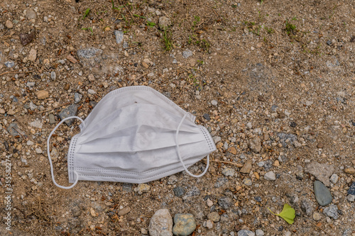 White medical face mask mask on ground.