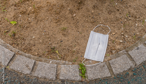White medical face mask on ground.