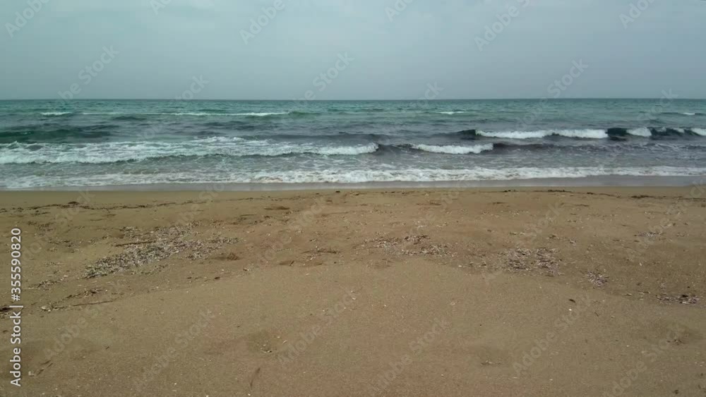 Mediterranean ocean waves crashing onto shore, overcast day, drone trucking Mediterranean ocean waves crashing onto shore, overcast day, drone trucking