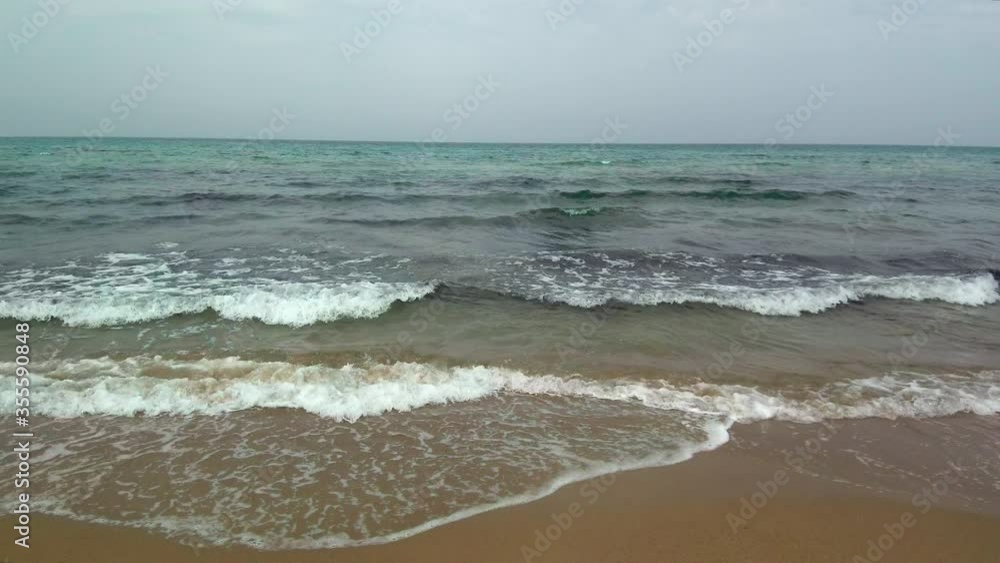 Ocean waves crashing onto empty shore during cloudy day, drone trucking Ocean waves crashing onto empty shore during cloudy day, drone trucking