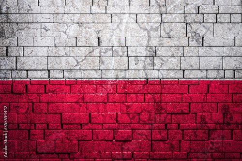 National flag of Poland on brick wall background.The concept of national pride and symbol of the country. Flag banner on stone texture background.