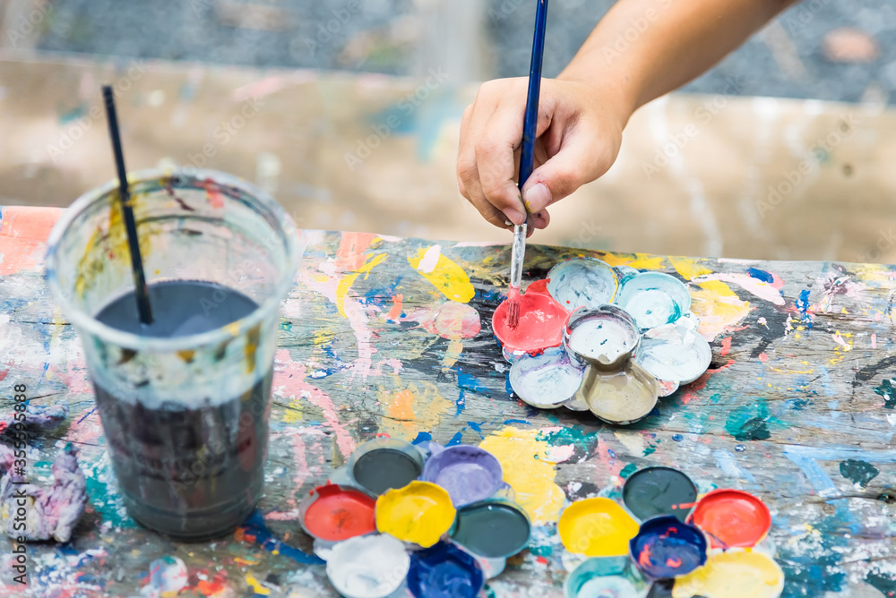 Child draws with watercolors sitting at the table. Child draws with watercolors sitting at the table.