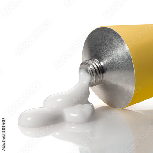 Open yellow tube with leaked white liquid