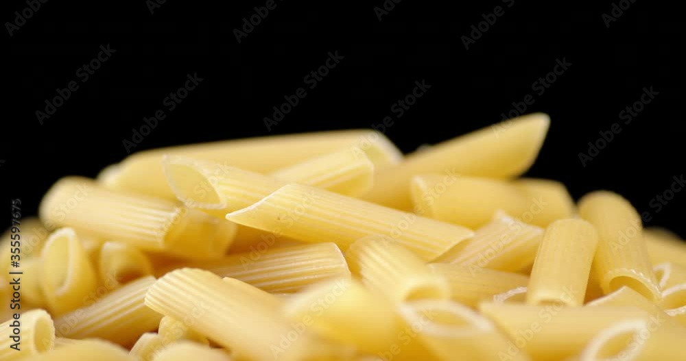 A handful of dry Penne pasta on the table slowly rotates. A handful of dry Penne pasta on the table slowly rotates.