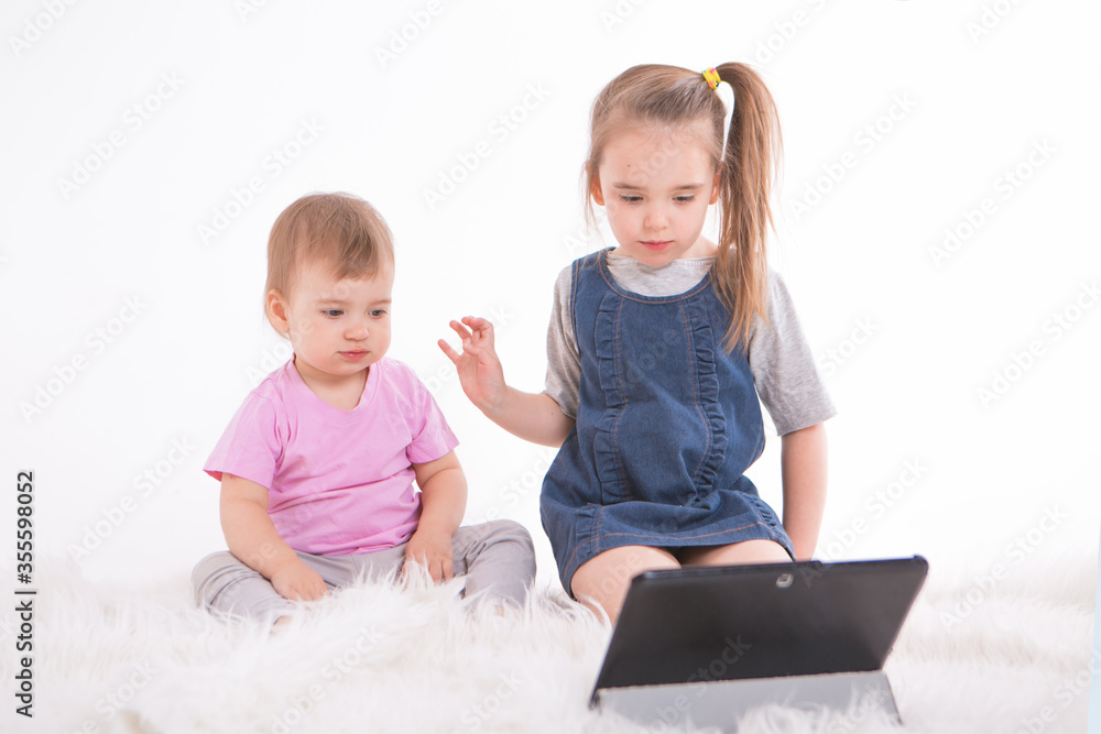 the kids are watching cartoons on the tablet. Home schooling for girls during quarantine the kids are watching cartoons on the tablet. Home schooling for girls during quarantine