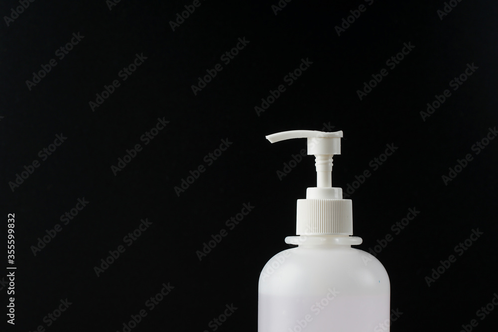 Sanitiser bottle over the black background to keep hand hygiene. New normal life during coronavirus disease cover-19 pandemic Sanitiser bottle over the black background to keep hand hygiene. New normal life during coronavirus disease cover-19 pandemic