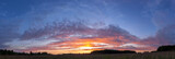 Panorama of sunset landscape of summer field under blue sky with clouds