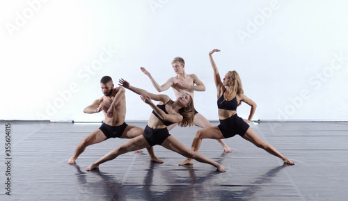 group of athletic dance partners in front of white background