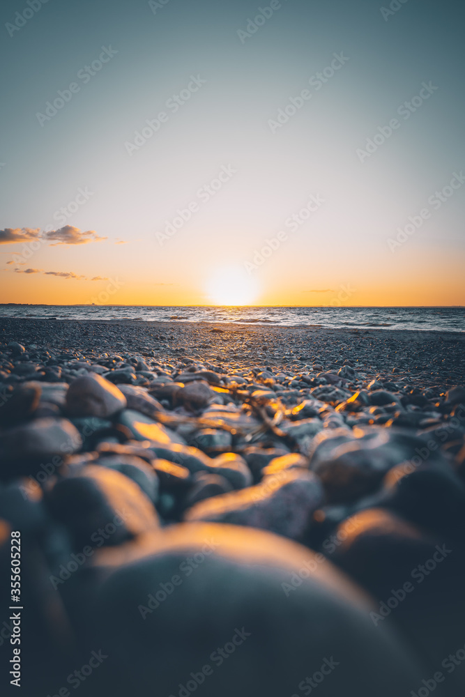 Obraz premium Sonnenuntergang an einem steinigen Strand an der Ostsee