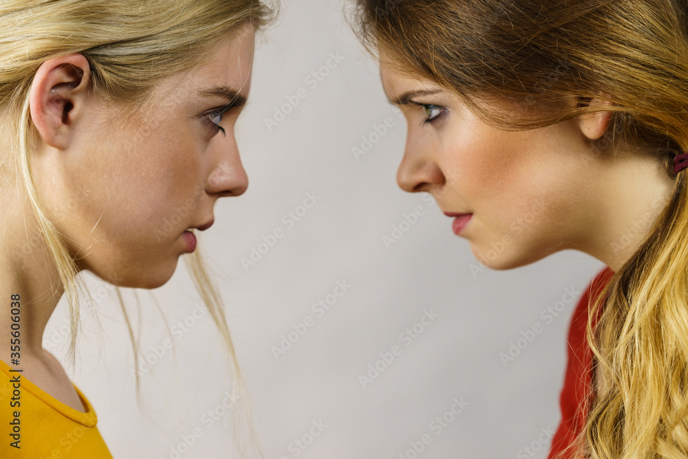 Two girls looking serious at each other. Two girls looking serious at each other.