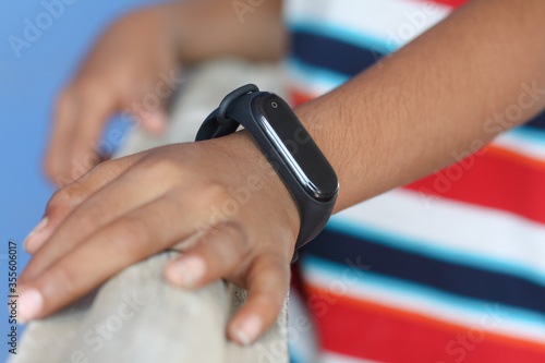 Indian boy wearing smartwatch in his hand