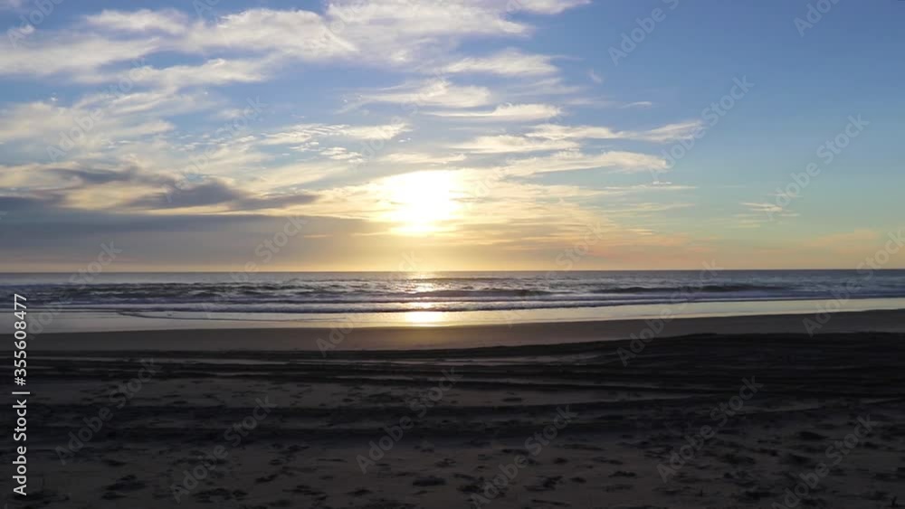Timelapse Of Sun Rising Over Ocean And Clouds Moving Through Sky At Dawn On A Beach Timelapse Of Sun Rising Over Ocean And Clouds Moving Through Sky At Dawn On A Beach