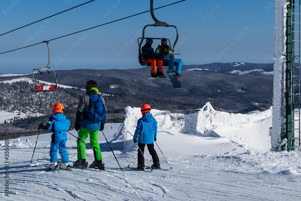 Ski, skiing, skiers on ski lift. Happy people enjoying winter vacations in mountains. Winter holidays