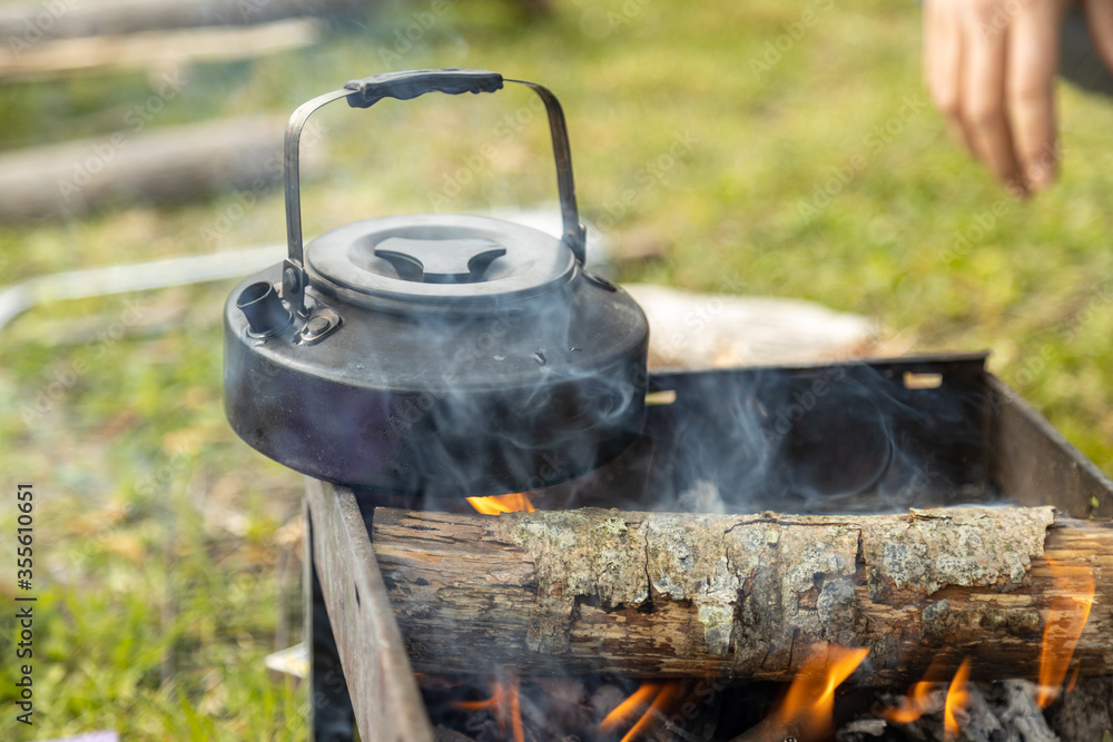 Teapot warming up on a camping fireplace. Teapot warming up on a camping fireplace.