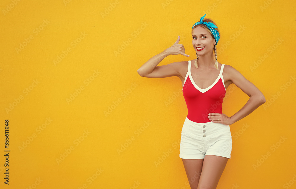 Call me, baby! Pretty young woman showing phone sign with her fingers. Colorful portrait with yellow background. Call me, baby! Pretty young woman showing phone sign with her fingers. Colorful portrait with yellow background.