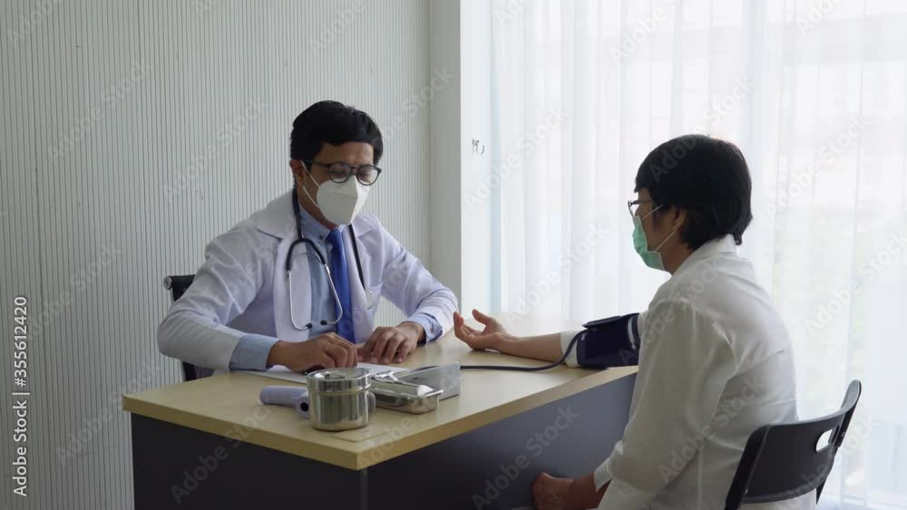 Asian doctor using digital sphygmomanometer to measure blood pressure of senior woman patient who visits at clinic in hospital. healthcare and medical concept Asian doctor using digital sphygmomanometer to measure blood pressure of senior woman patient who visits at clinic in hospital. healthcare and medical concept