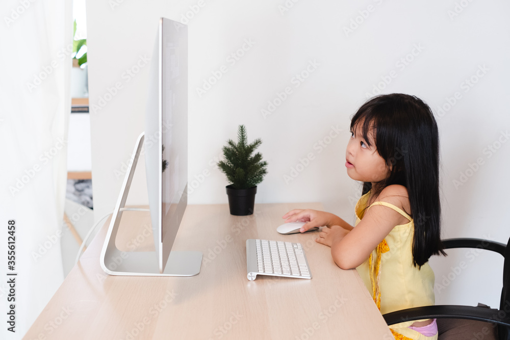 Asian Child Cute and happy little girl children using computer, studying through online e-learning system. Asian Child Cute and happy little girl children using computer, studying through online e-learning system.
