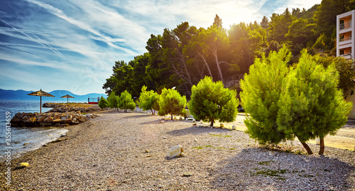 Amazing sunset at rocky beach near Brela town, Makarska riviera, Dalmatia, Croatia. Adriatic sea. Beautiful world of Mediterranean countries.