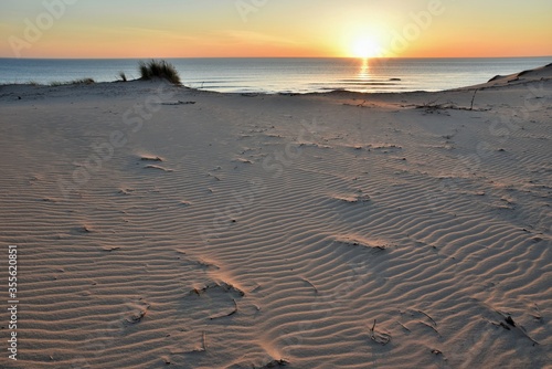 Coucher de soleil sur la c  te atlantique fran  aise     Soulac-sur-Mer. Les dunes sont stri  es par le vent. Le paysage est tr  s color   gr  ce    la lumi  re du soleil couchant et    l oc  an. Tout est calme.