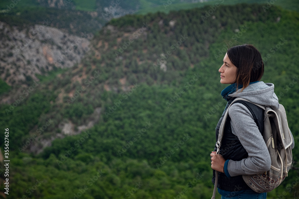 Young traveling woman on the top of the mountain cliff Young traveling woman on the top of the mountain cliff