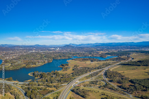 Aerial panoramic view looking over Glenloch Interchange and Lake Burley Griffin on a sunny day 