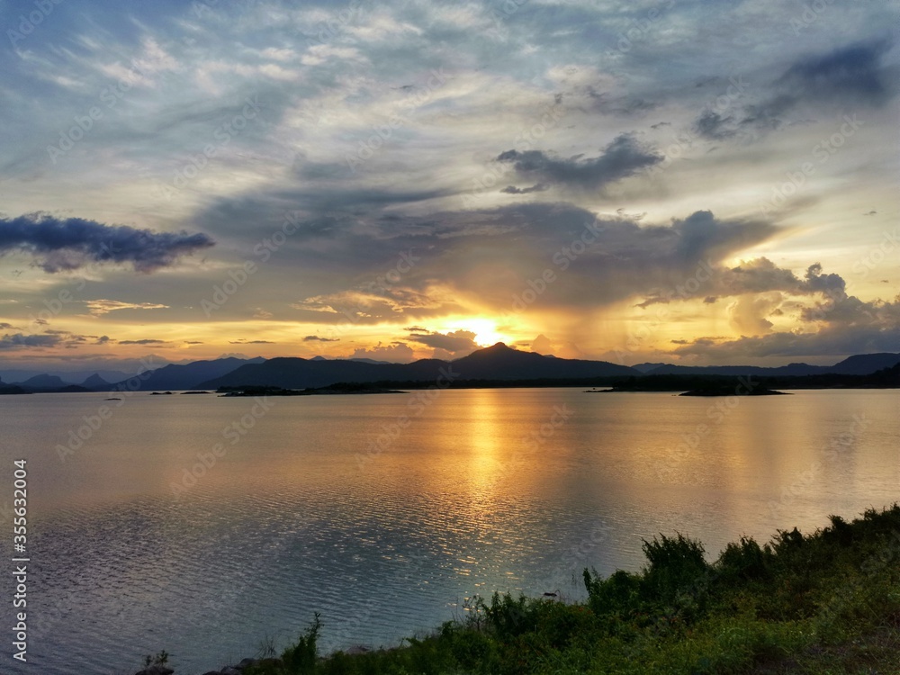 A beautiful landscape capture at Inginiyagala Dam, Sri Lanka. Sunset with cloudy sky and the yellow reflection in the water is amazing to see here.