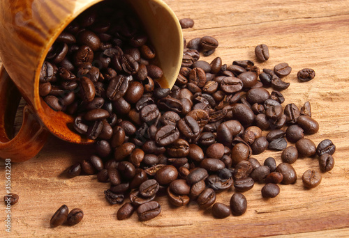 Ceramic coffee mug with coffee beans on wood.