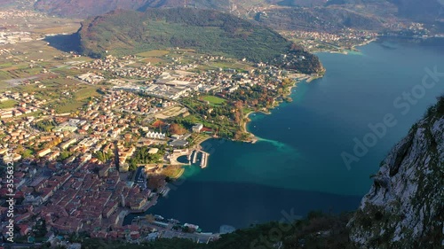 Aerial video with drone, view of the beautiful Riva del Garda town and Lake Garda lake surrounded by mountains in the autumn time , Trentino Alto Adige region, Lago di garda, italy
