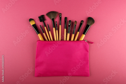 set of makeup brushes in a pink cosmetic bag top view. concept of make up artist. 