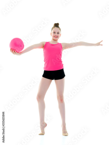 little girl is engaged in fitness with a ball.