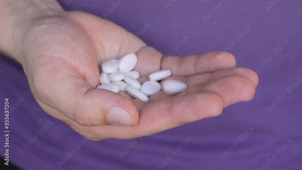 White therapeutic pills antibiotic treatment, medical painkiller, calcium supplements poured into person palm, medicines and health care concept, close-up view White therapeutic pills antibiotic treatment, medical painkiller, calcium supplements poured into person palm, medicines and health care concept, close-up view