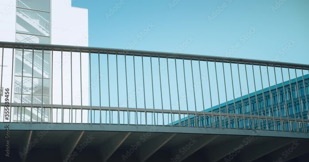 Female commuter goes to work or home on city bike. Cycling infrastructure of European city, elevated bike lane bridge in business district. Green and sustainable mobility solutions for traffic Female commuter goes to work or home on city bike. Cycling infrastructure of European city, elevated bike lane bridge in business district. Green and sustainable mobility solutions for traffic