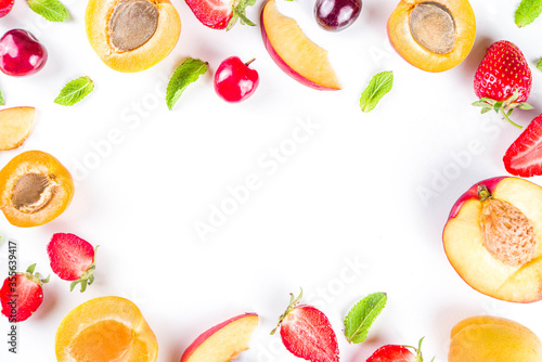 Summer background with fresh fruits and berries on white background. Set of various seasonal fruit and berry - strawberry, apricots, peach slices, cherry, mint. Flat lay. Summer fruits concept.
