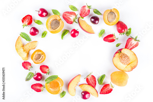 Summer background with fresh fruits and berries on white background. Set of various seasonal fruit and berry  - strawberry, apricots, peach slices, cherry, mint. Flat lay. Summer fruits concept.